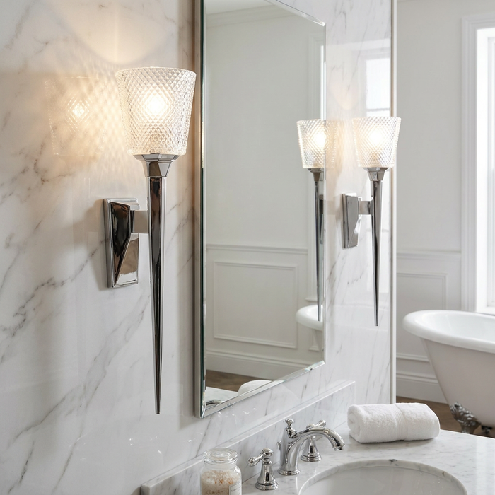Verity polished chrome wall lights with textured glass shades mounted on a marble bathroom wall beside a mirror.