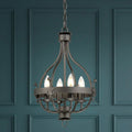 Traditional graphite 4-light pendant with candle bulbs hanging against a dark teal paneled wall.