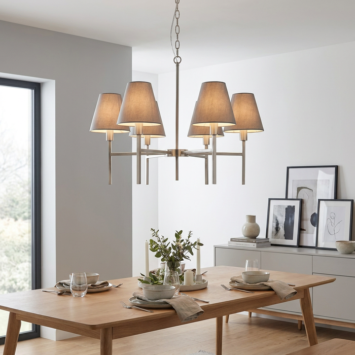 Elstead Lucerne 6-light brushed nickel chandelier with grey fabric shades hanging above a modern wooden dining table.