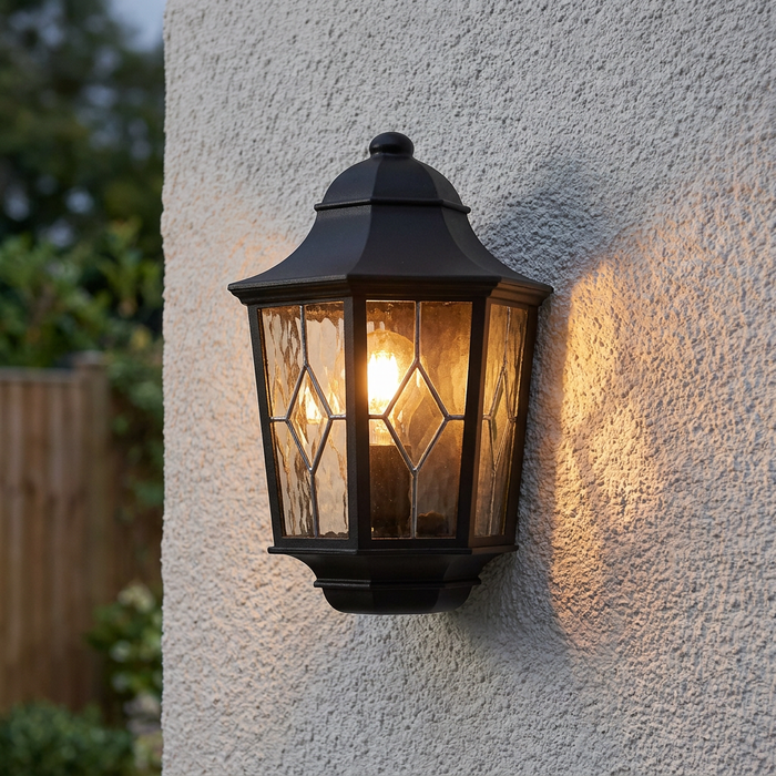 Elstead Norfolk black outdoor half wall light with leaded glass panels mounted on a white textured exterior wall.