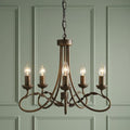 Elstead Olivia 5-light chandelier with bronze-finished scrollwork and leaf details against a green paneled wall.