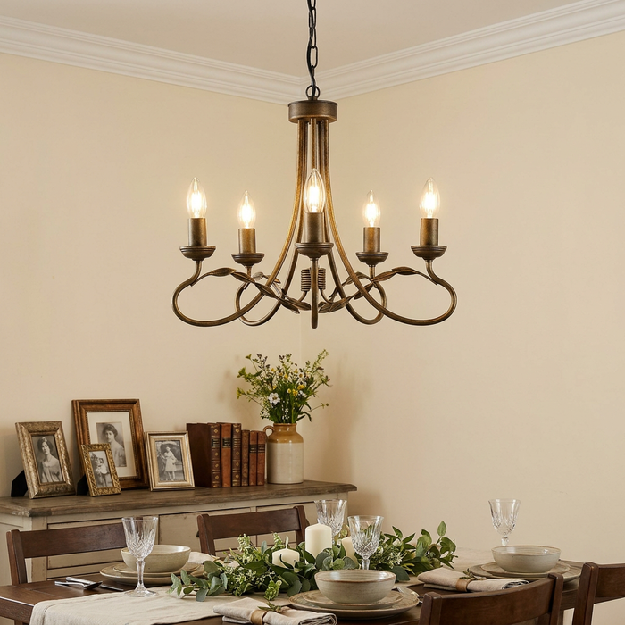 Classic black and gold 5-light chandelier hanging over an elegantly set dining table in a rustic room.