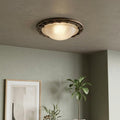 Elstead Olivia flush ceiling light with textured glass and bronze leaf trim mounted in a green-walled room.