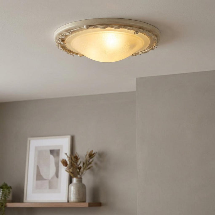 Elstead Olivia ivory and gold flush mount ceiling light with frosted glass bowl in a contemporary room setting.