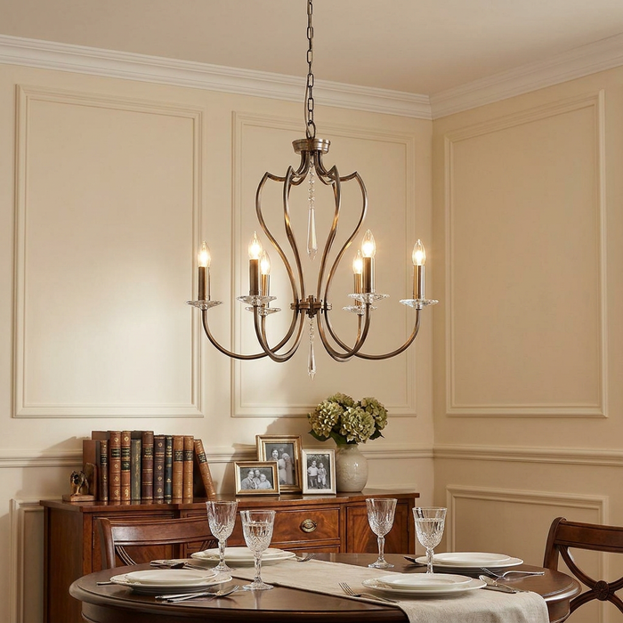 Dark bronze 6-light chandelier with crystal accents hanging over a set dining table in a classic interior.