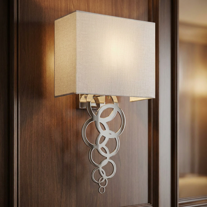 Elegant wall sconce with a cream fabric shade and chrome ring cascade mounted on dark wood panelling.