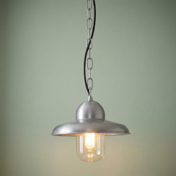 Antique nickel outdoor pendant light with a clear glass shade and silver chain against a pale green background.