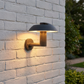 Elstead Spril medium graphite LED outdoor wall light illuminating a white brick wall.