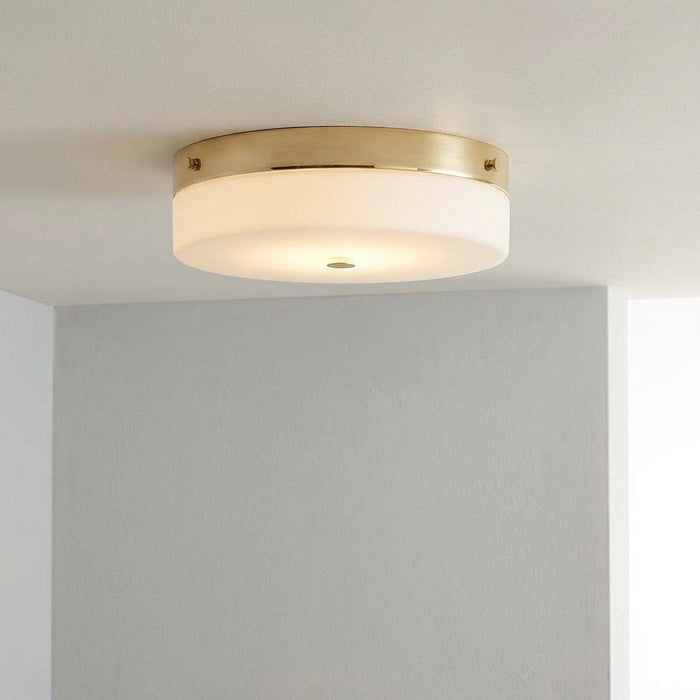 Large gold-framed flush ceiling light with a frosted white glass drum shade mounted on a white ceiling.