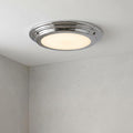 Circular flush-mounted bathroom ceiling light with a polished chrome trim and glowing frosted diffuser.