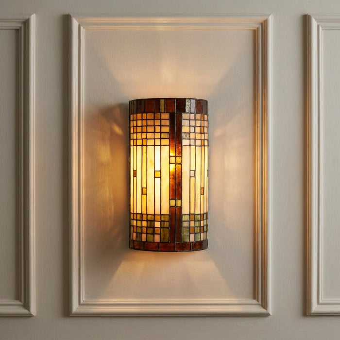 Empire Tiffany wall light featuring a geometric stained glass shade, mounted on a cream paneled wall.