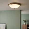 Brass flush ceiling light with a frosted glass bowl and ribbed metal rim mounted on a white ceiling.
