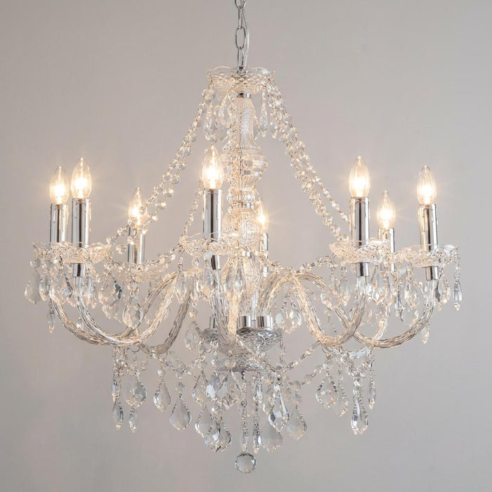 Elegant 8-light chrome and clear acrylic chandelier with lit candle bulbs and draped crystal-effect beads.
