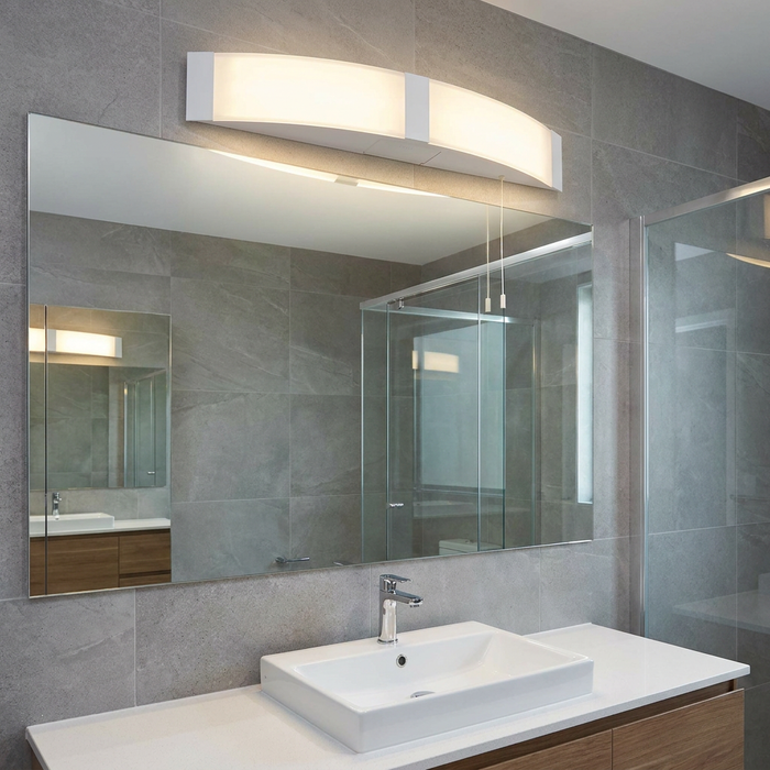 Curved white LED wall light with pull cords mounted above a bathroom mirror.