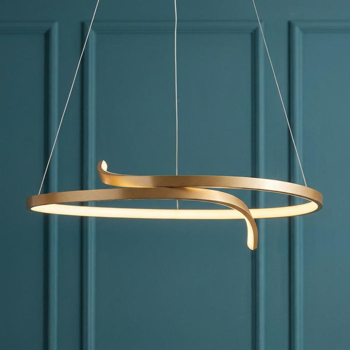 Modern gold curved ring LED pendant light suspended against a teal wainscoted wall.