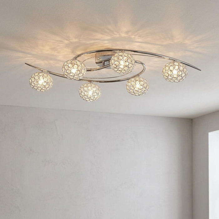 Eva 6 light polished chrome and crystal semi-flush ceiling light casting patterned shadows in a modern room.