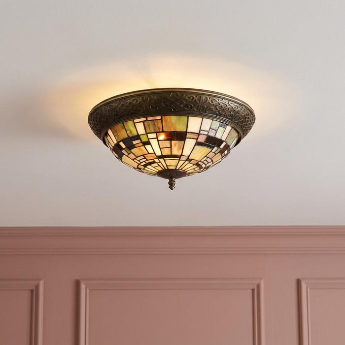 Falling Water Tiffany flush ceiling light with geometric stained glass shade on a white ceiling above a pink wall.