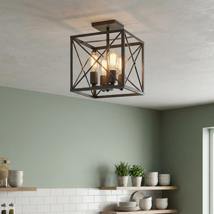 Square cage lantern ceiling light with four glowing filament bulbs installed in a kitchen with green walls.