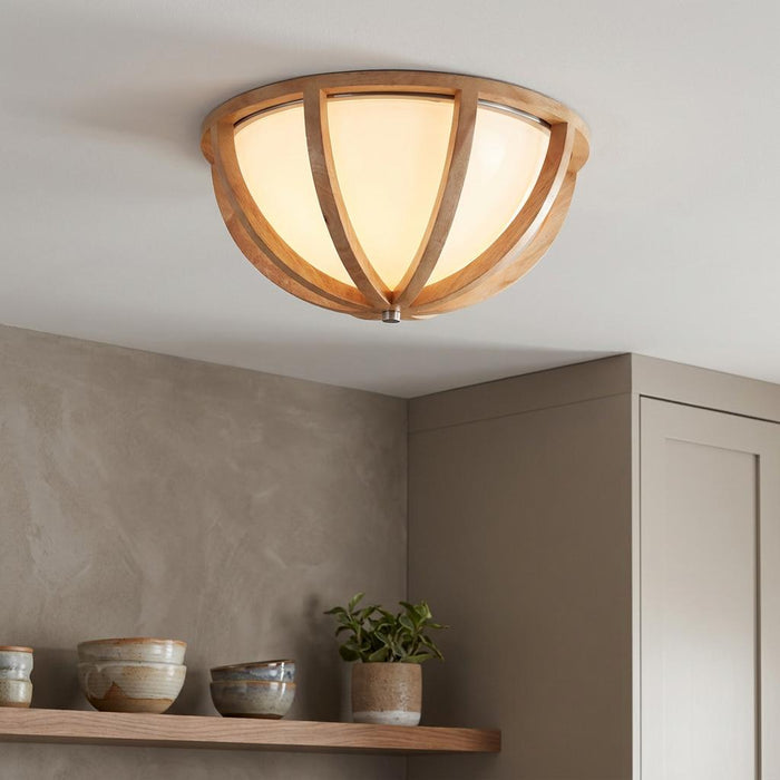 Feiss Allier flush mount light with curved wooden ribs and a frosted glass shade installed in a neutral kitchen.