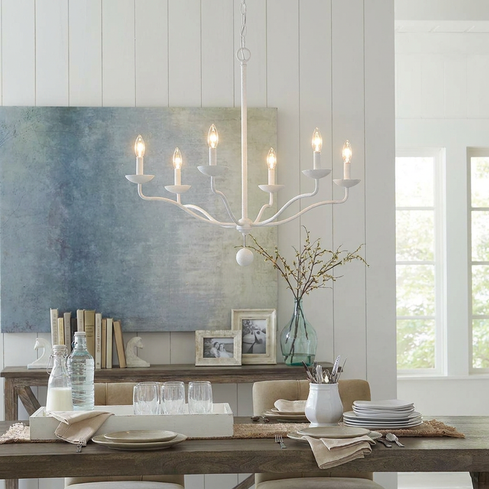White six-light Feiss Annie chandelier with elegant curved arms suspended over a set dining room table.