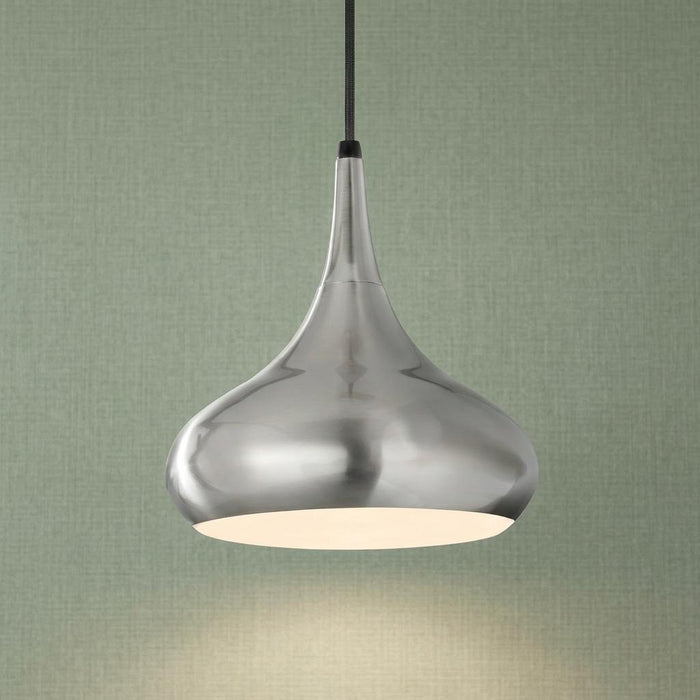 Brushed steel teardrop pendant light against a green textured wall, emitting a soft downward glow.