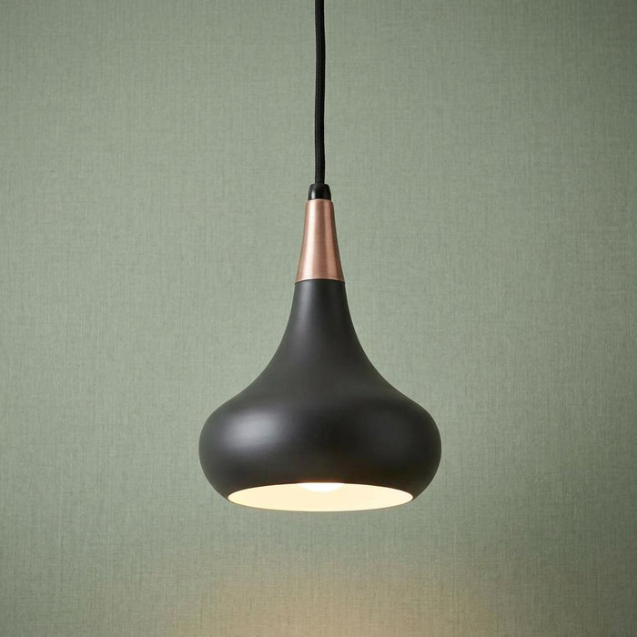 Modern dark bronze teardrop pendant light with copper accent hanging against light green wallpaper.