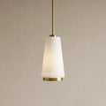 Tapered matte white pendant light with brass accents and vertical slits at the bottom against a neutral wall.