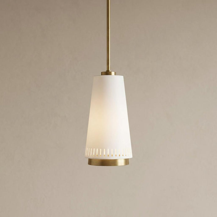 Tapered matte white pendant light with brass accents and vertical slits at the bottom against a neutral wall.