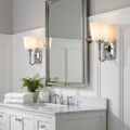 Feiss Concord polished chrome wall lights with frosted shades flanking a bathroom mirror on a white paneled wall.