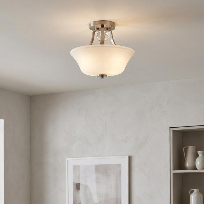 Feiss Evington satin nickel semi-flush ceiling light with a glowing white glass shade in a modern room.