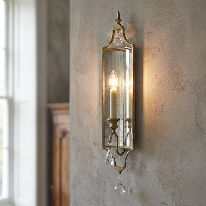 Feiss Gianna 1 light gilded silver wall light with mirrored backing and crystal drops on a textured wall.