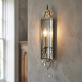 Feiss Gianna 1 light gilded silver wall light with mirrored backing and crystal drops on a textured wall.
