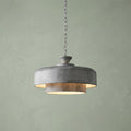 A galvanized steel two-tier pendant light hanging from a chain against a pale green textured wall.