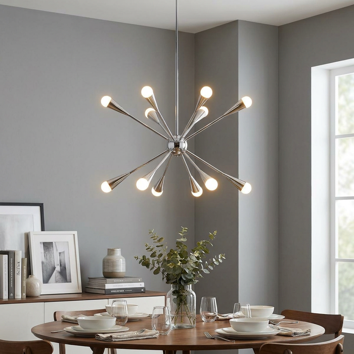 A starburst-style polished nickel chandelier hanging over a set wooden dining table in a contemporary grey room.