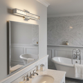 Polished chrome LED wall light with faceted crystals mounted above a vanity mirror in an elegant bathroom.