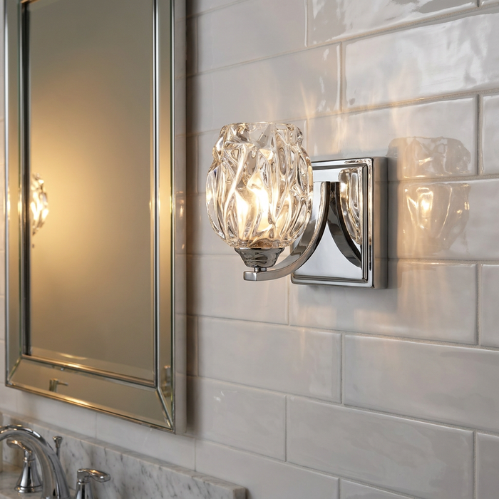 Feiss Kalli polished chrome wall light with a textured glass shade mounted on a white subway tile bathroom wall.
