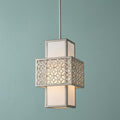 Silver mini-pendant light with geometric fretwork and white shade, glowing against a teal background.