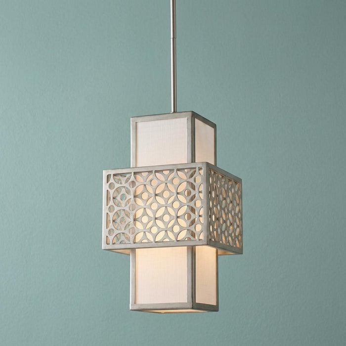 Silver mini-pendant light with geometric fretwork and white shade, glowing against a teal background.