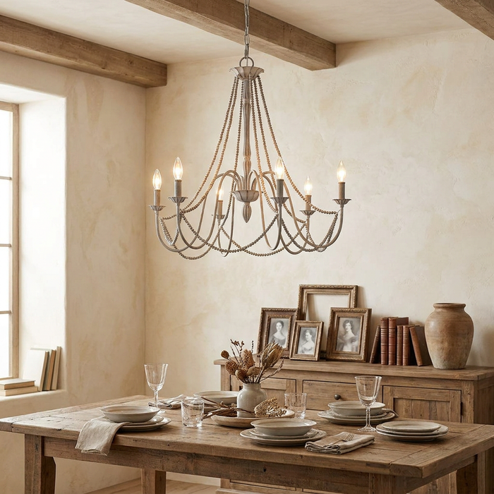Feiss Maryville 6-light grey chandelier with beaded strands hanging over a rustic wooden dining table.