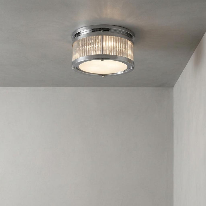 Chrome flush mount ceiling light with ribbed glass sides and a frosted bottom panel against a grey concrete ceiling.