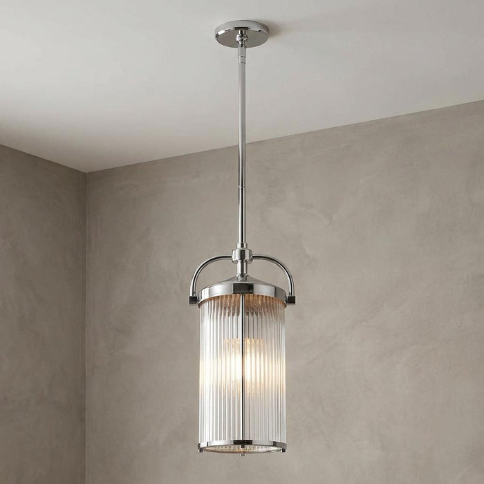 Feiss Paulson chrome 3-light pendant with a ribbed glass cylinder shade hanging from a neutral ceiling.