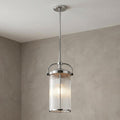Feiss Paulson chrome 3-light pendant with a ribbed glass cylinder shade hanging from a neutral ceiling.