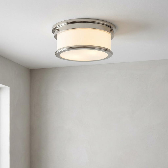 Feiss Payne polished nickel flush bathroom ceiling light with a white opal glass drum shade mounted on a ceiling.