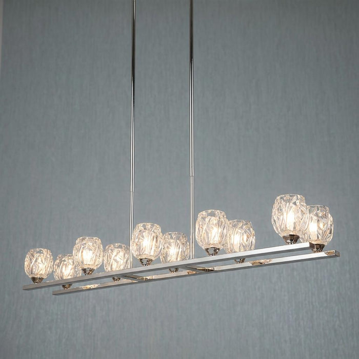 Feiss Rubin 10-light island chandelier in polished nickel with faceted crystal shades against a blue background.