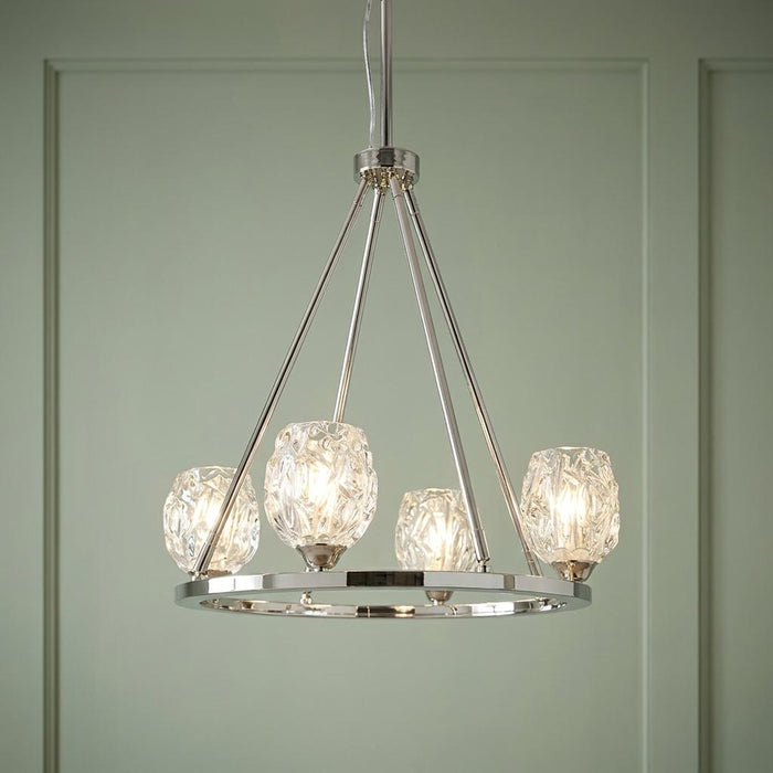 Feiss Rubin 4-light chandelier in polished nickel with textured glass shades against a sage green wall.