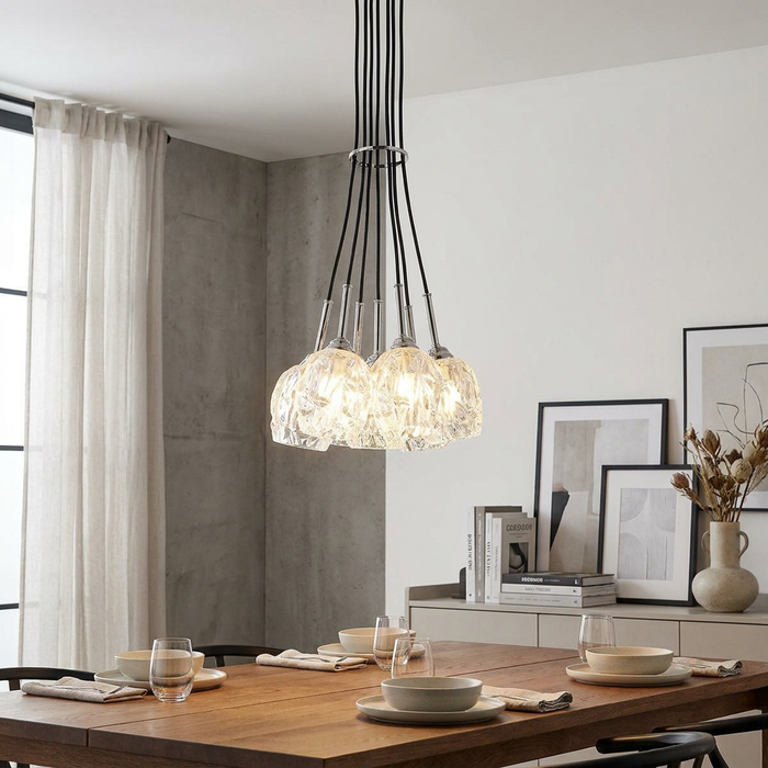Feiss Rubin 7-light cluster chandelier with textured glass shades hanging over a modern wooden dining table.