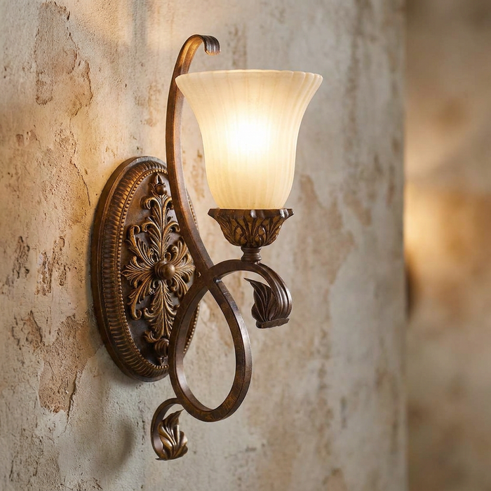 Feiss Sonoma Valley wall sconce with ornate bronze scrollwork and cream glass shade on a rustic plaster wall.