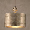Large silver pendant light with an etched drum shade and a distressed cross detail at the top.