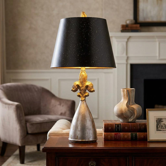 Flambeau Rodrigue table lamp featuring a silver fleur-de-lis base and a black shade with gold speckles.