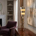 Elegant silver and cream striped table lamp with crystal accents on a dark wood desk in a living room.